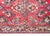 A petite early 20th century Persian Sarouk rug with a mirrored floral pattern across the field, surrounded by a simple...
