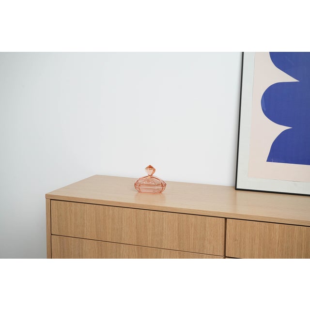 The pink butter dish was made in the 1930s in Italy. A geometric butter dish made of pink pressed glass in the Art Deco...