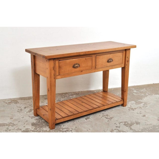 This pine side table with two drawers and a practical shelf underneath is in excellent condition. It dates from the 1930s...