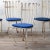 A set of four scrolled wrought iron chairs in cobalt blue outdoor fabric, circa 1940s. each chairs measuring 16 inches...