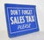 Vintage retail cardboard wall sign with a blue background and white lettering. The sign reads, Don't forget Sales Tax...