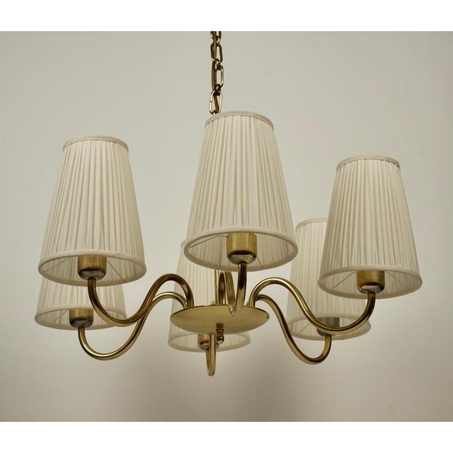 A beautiful six arm chandilier in brass from oswald haerdtl from the 1930's. The metal a has been restored: polished and...