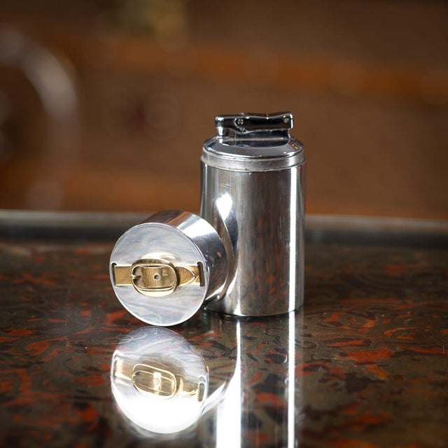 A superb 20th century french silver plated table lighter by hermès, paris. Crafted in a cylinder form with a gilt horsebit...