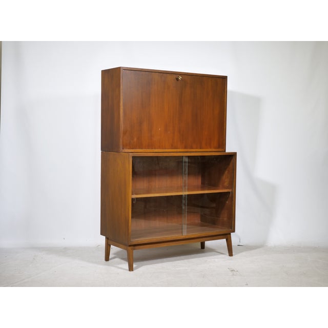 Mid-century teak secretary/bar with display cabinet, 1960s. Two-part design with a closed writing surface at the top and a...