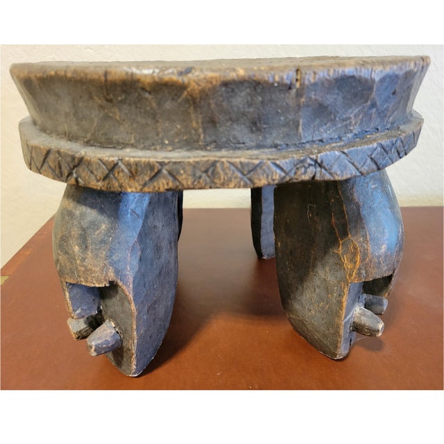 Beautiful hand carved African round teak stool. The legs have carved faces on them with geometric carvings on the top. The...