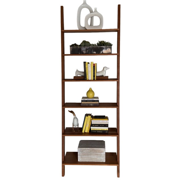 Ladder-style bookcase by Room & Board, finished in a warm walnut tone. The design features clean vertical supports and...