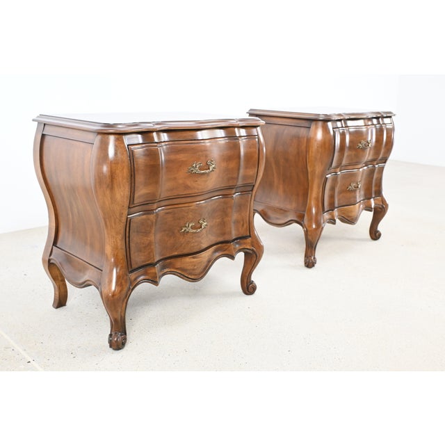 This elegant pair of French Louis XV style nightstands is crafted from rich walnut, showcasing a classic bombe silhouette,...