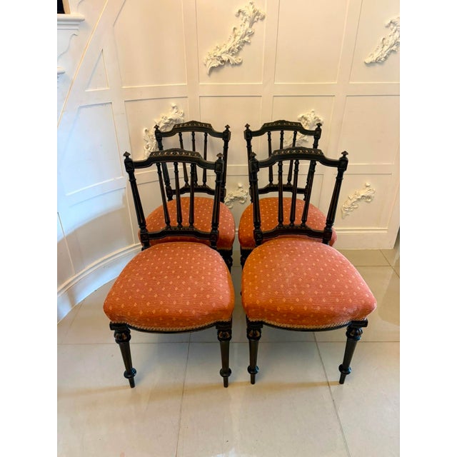 A decorative set of four Victorian ebonised and gilt dining chairs dating to circa 1880, with elegant spindle backs,...