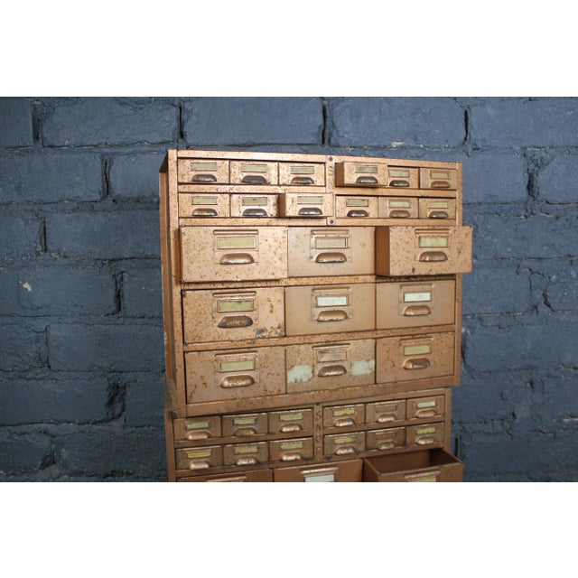 These two SNOR craft or workshop units, with their multiple drawers, are functional pieces. Their original copper paint,...
