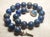 This necklace measures 18 inches (45.7 cm) in length and features smooth, round beads, each 20 mm in size. The lapis...