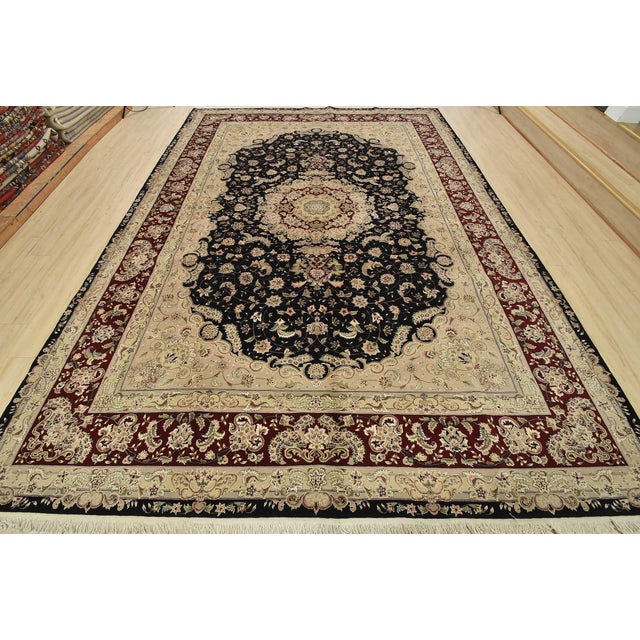 A traditional Tabriz rug hand-knotted with fine wool and silk highlights on a cotton foundation. This intricately woven...