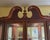 This stately, late 20th-century china cabinet features a swan-neck (broken) pediment with a central finial, multi-pane...