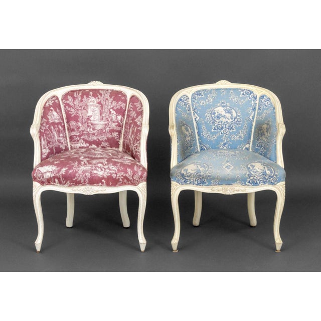 Pair of Louis XV Style White Painted Bergeres, with toile du jour upholstery, one in red and one in blue, on cabriole...
