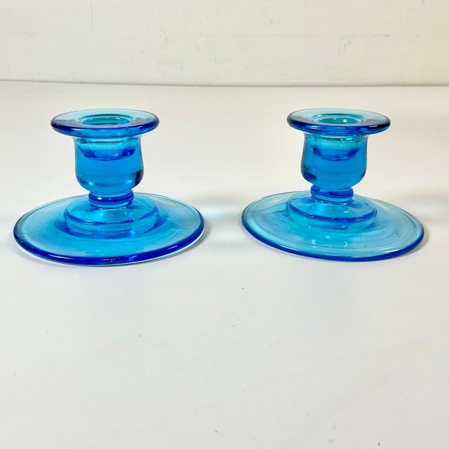 These are a pair of gorgeous turquoise ocean blue Depression Era glass candle holders. The design is a tulip cup on a low-...