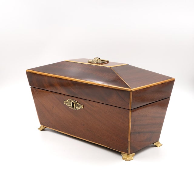 An English Regency mahogany box of tapered rectangular form with a pyramidal lid outlined in satinwood stringing. The lid...