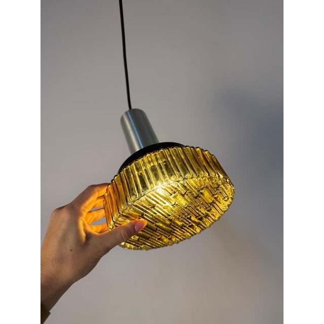 An atmospheric highlight of the 1970s: This brown pendant lamp brings the unmistakable, cozy look of the Space Age era...