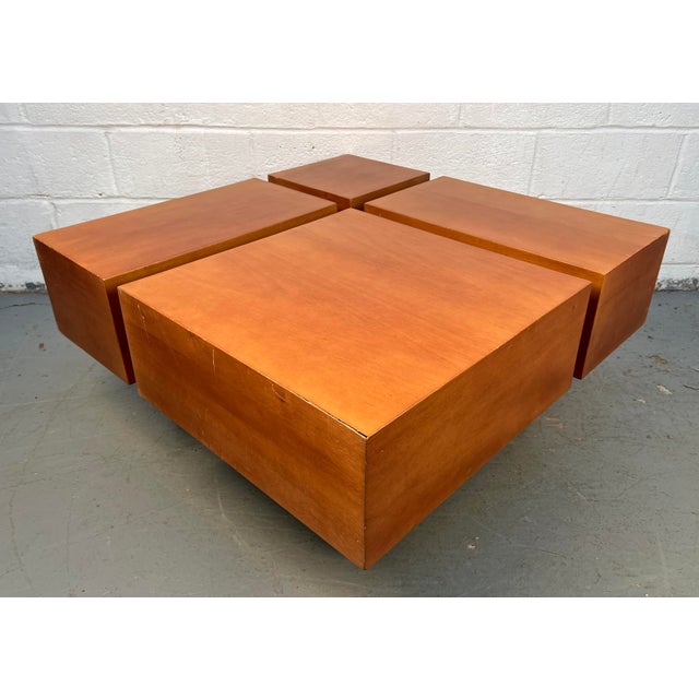 A mid-century modern–style wooden square coffee table featuring clean lines and a warm, natural finish. Its simple...