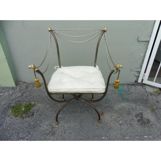 Fab brass and steel Neoclassical Savonarola chair with rams heads and tassels sold as found without damage measuring 34.75...