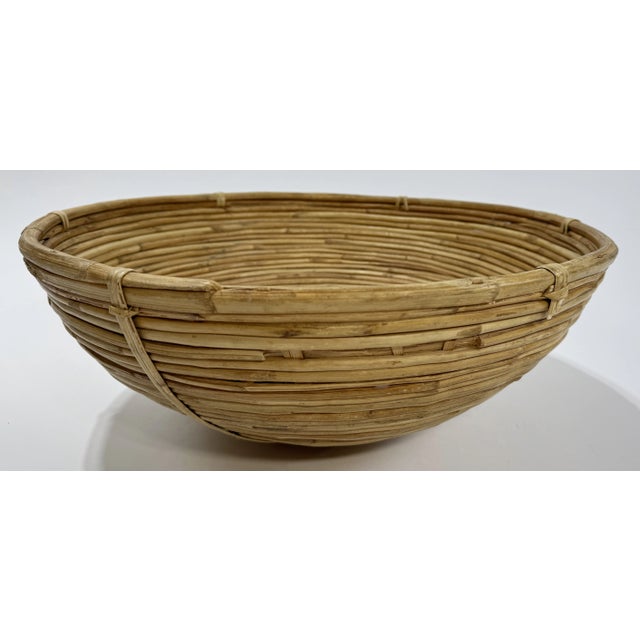 Substantial vintage bowl made of coiled split pencil reed rattan. Age wear. Breaks to exterior perpendicular reeds do not...