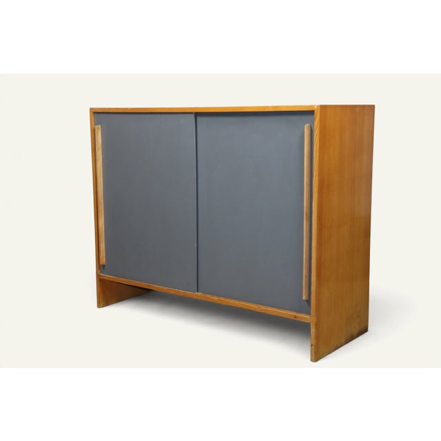 A stylish side table from the 1960s, with a clean, graphic design. It combines a honey-toned wooden frame with two bluish-...