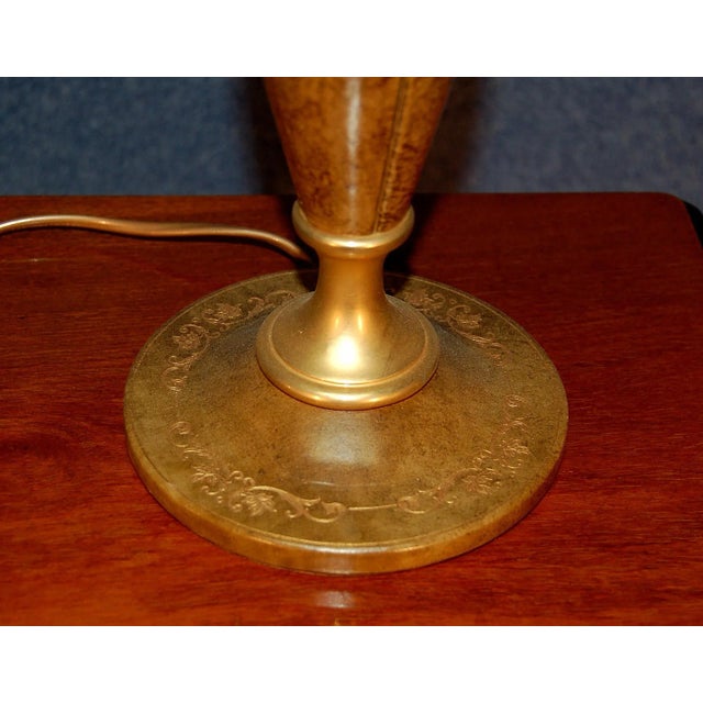 This golden brass and leather lamp with gilded branding irons is signed Le Tanneur and was made in the 1970s. The piece...