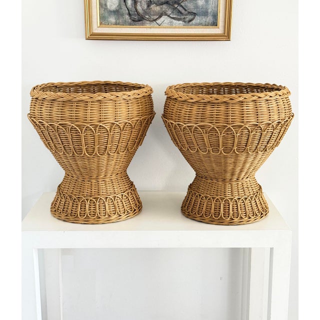 Two large rattan pedestal planter baskets in excellent condition. 17 x 17 x 18h Perfect for a fern or small Evergreen trees.