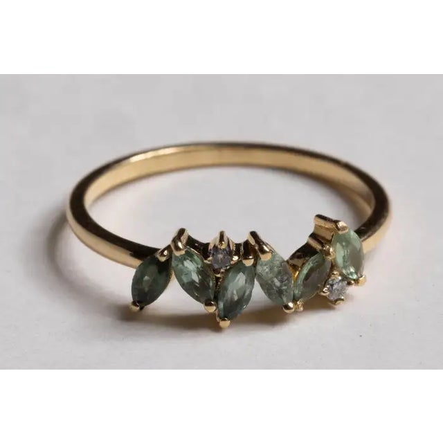 A lovely cluster of six marquise, faceted green tourmaline gemstones with two round, brilliant cut diamonds interspersed....