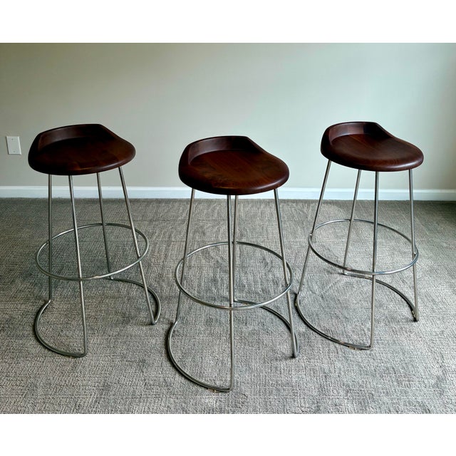 A sophisticated set of three swivel bar stools by McGuire, showcasing the brand’s signature balance of refined organic...