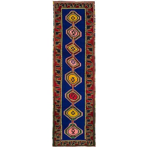 This exquisite runner rug is a rare example of tribal craftsmanship, hand-knotted by the women of the Herki tribe during...