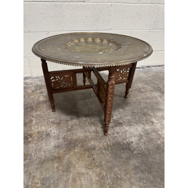 Unusual Moroccan style brass tray with folding teak base. Brass Is tarnished and patina’d in few spots. Very stable for...