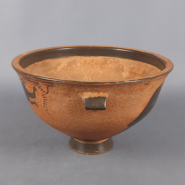 A magnificent terracotta skyphos jug, handcrafted in a captivating style reminiscent of ancient Greek pottery. This piece...