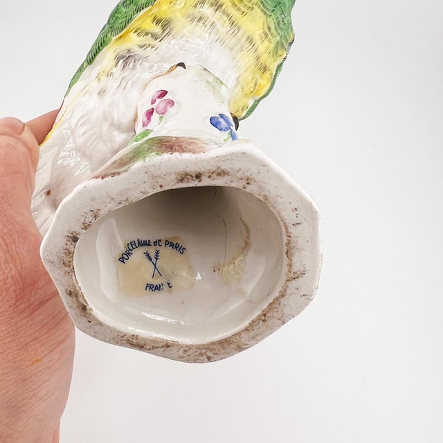 A striking and highly decorative French porcelain parrot sculpture by Porcelaine de Paris, beautifully hand-painted in...