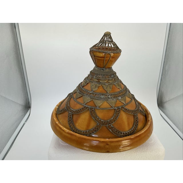 A beautifully detailed vintage Moroccan tagine featuring an elegant ceramic form embellished with an intricate silver-tone...
