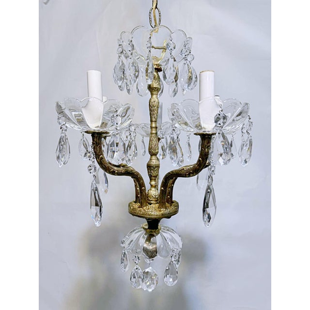 This is a Spanish style chandelier with ornate brass frame and vintage almond shaped crystals. It has 5 arms that each use...