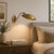 Crafted in solid brass, this handcrafted wall sconce features a graceful curved arm, a wide sculptural dome shade, and a...