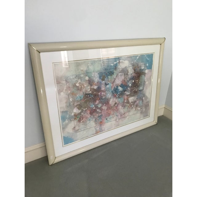 Pastel abstract monoprint painting titled “Camouflage Park IV” in a cream lacquered frame with brass accents at corners....