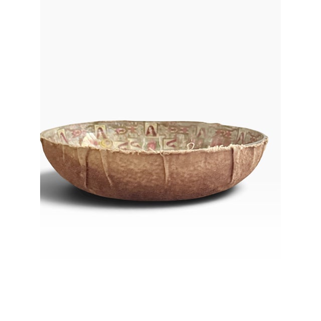 An intricate parlor-craft bowl decorated with overlapping cigar bands arranged around a central photographic portrait of a...