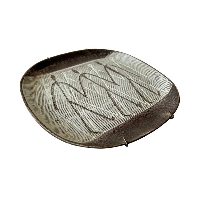 A rare, mid-century wall plate with primitive incised design and textured glaze by Nancy Wickham (1923-1987). Piece...