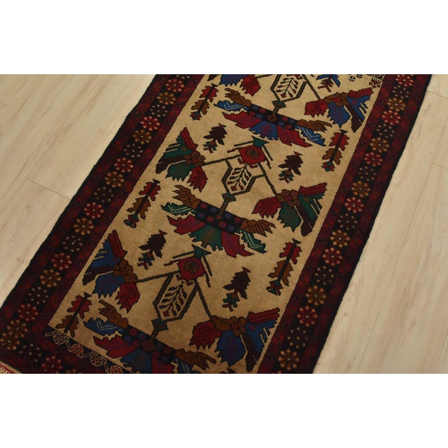 An authentic vintage tribal Baloch rug hand-knotted with fine wool and natural dyes. This nomadic oriental rug features an...