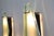 Large pair of 1943 model wall sconces, featuring a brass and metal frame and satin-finish glass shades with beveled edges,...
