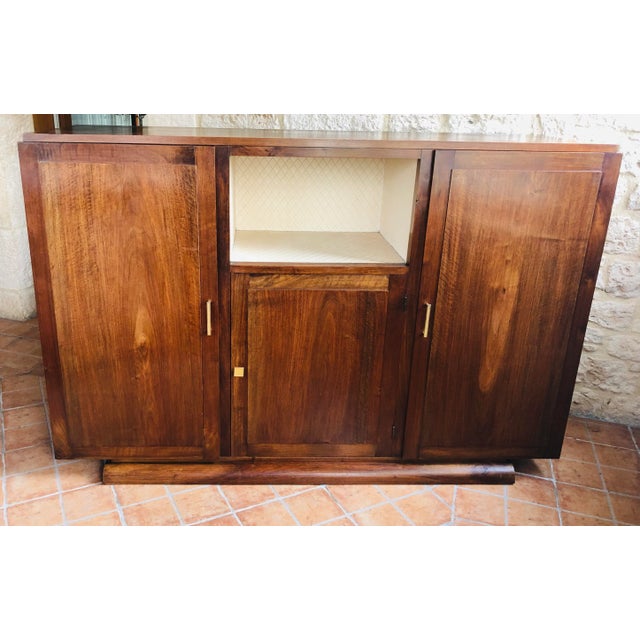 Art deco, low buffet made of walnut with a veneer finish. Piece has two tall cabinets on each side, and a smaller, lower...