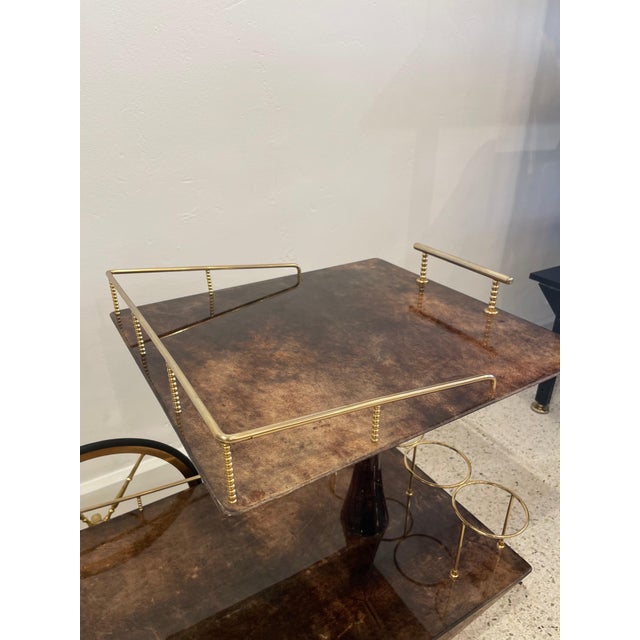 An original vintage Aldo Tura bar cart in dark brown lacquered goatskin and gold plated metal. Very geometric design and...