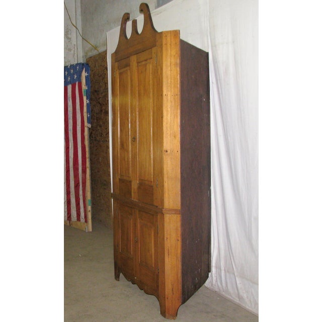 Early American solid cherry corner cabinet. A broken arch pediment and the original finish lend a classic air to this...