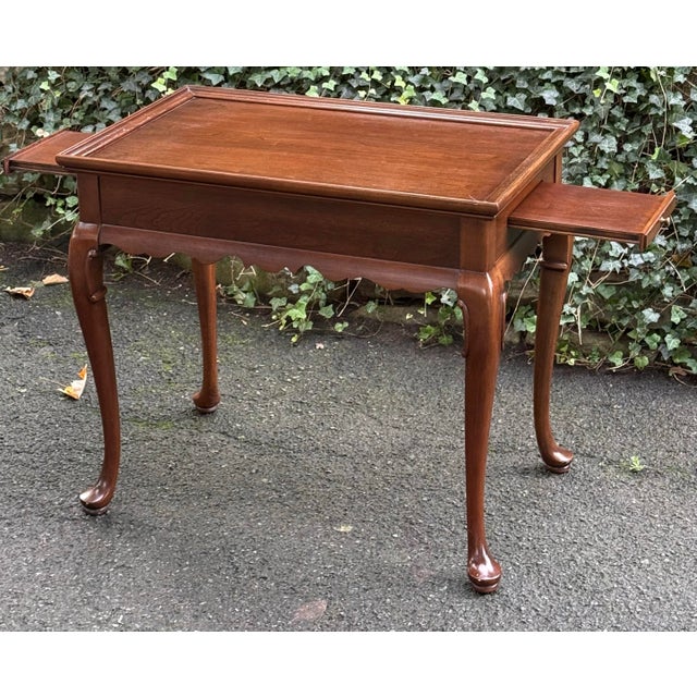 Beautifully crafted Ethan Allen tea table featuring a rich, warm wood finish and timeless Queen Anne styling. This elegant...