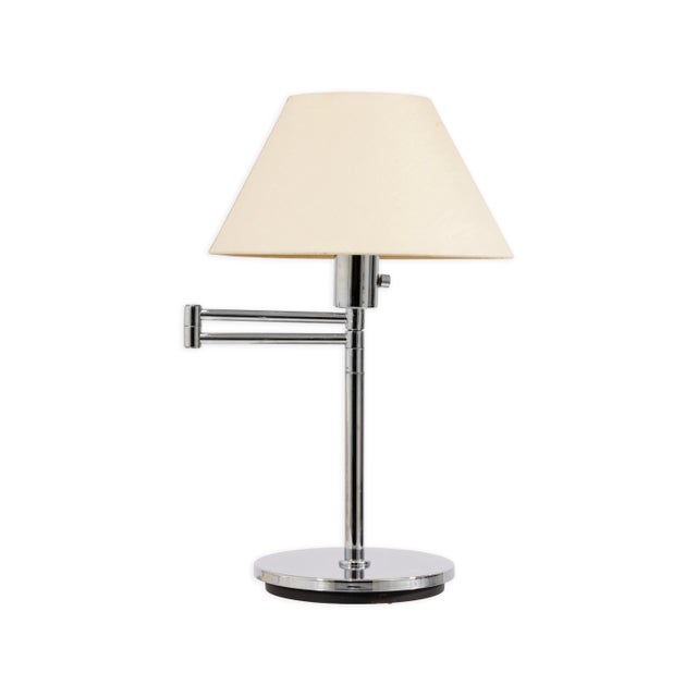This pair of Von Nessen chrome swing arm table lamps exemplifies sleek modernist design with an emphasis on function and...