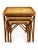 A charming set of three vintage bamboo and woven rattan nesting tables featuring warm, naturally aged finishes and classic...