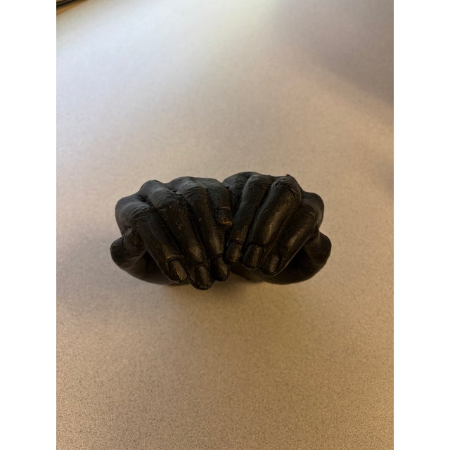 Add a sculptural touch to your space with this striking black decorative bowl featuring a pair of cupped hands. Its...
