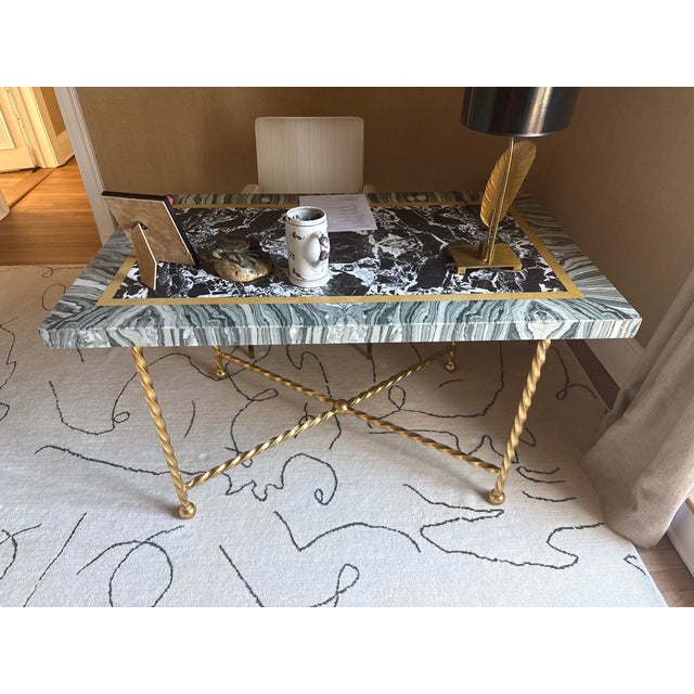 Exceptional Italian center table or desk featuring a sculptural hand-twisted gilt iron base supporting a substantial inset...