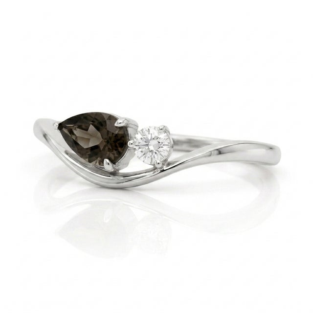 Exude sophisticated, dramatic charm with this sleekly swooping silhouette, holding a rich, earthy gem paired against a...