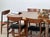 Danish set of eight dining chairs in teak, designed by Harry Østergaard, 1960s. Each chair pairs a crescent-shaped teak...
